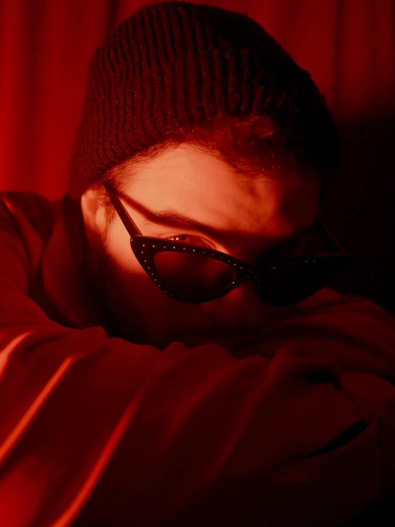 Close portrait in red light and black sunglasses